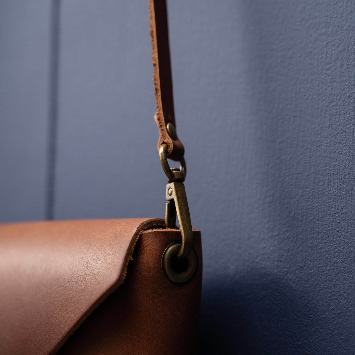 Handmade envelope purse featuring 3 in 1 leather strap. Wear as a clutch, wristlet, crossbody, or over the shoulder. Made with full grain leather. Available in black, brown, or tan.
