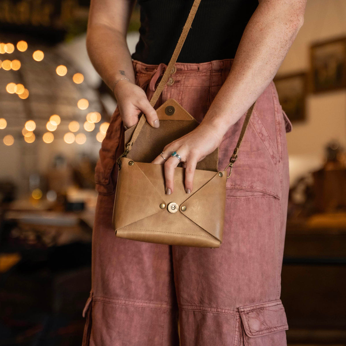 Handmade envelope purse featuring 3 in 1 leather strap. Wear as a clutch, wristlet, crossbody, or over the shoulder. Made with full grain leather. Available in black, brown, or tan.