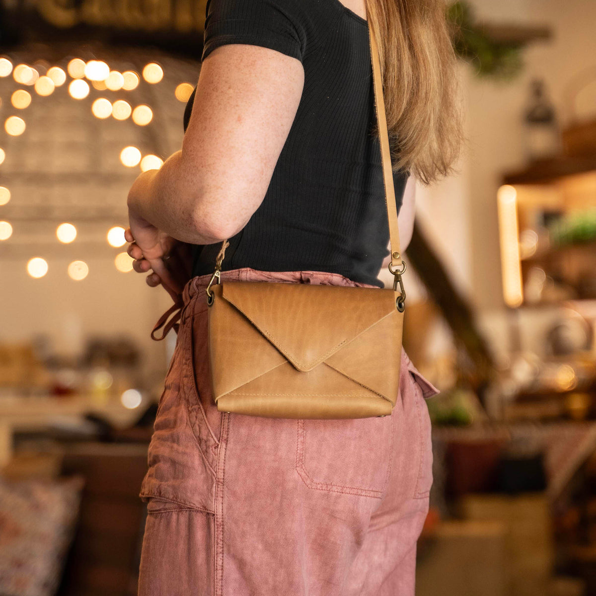 Handmade envelope purse featuring 3 in 1 leather strap. Wear as a clutch, wristlet, crossbody, or over the shoulder. Made with full grain leather. Available in black, brown, or tan.
