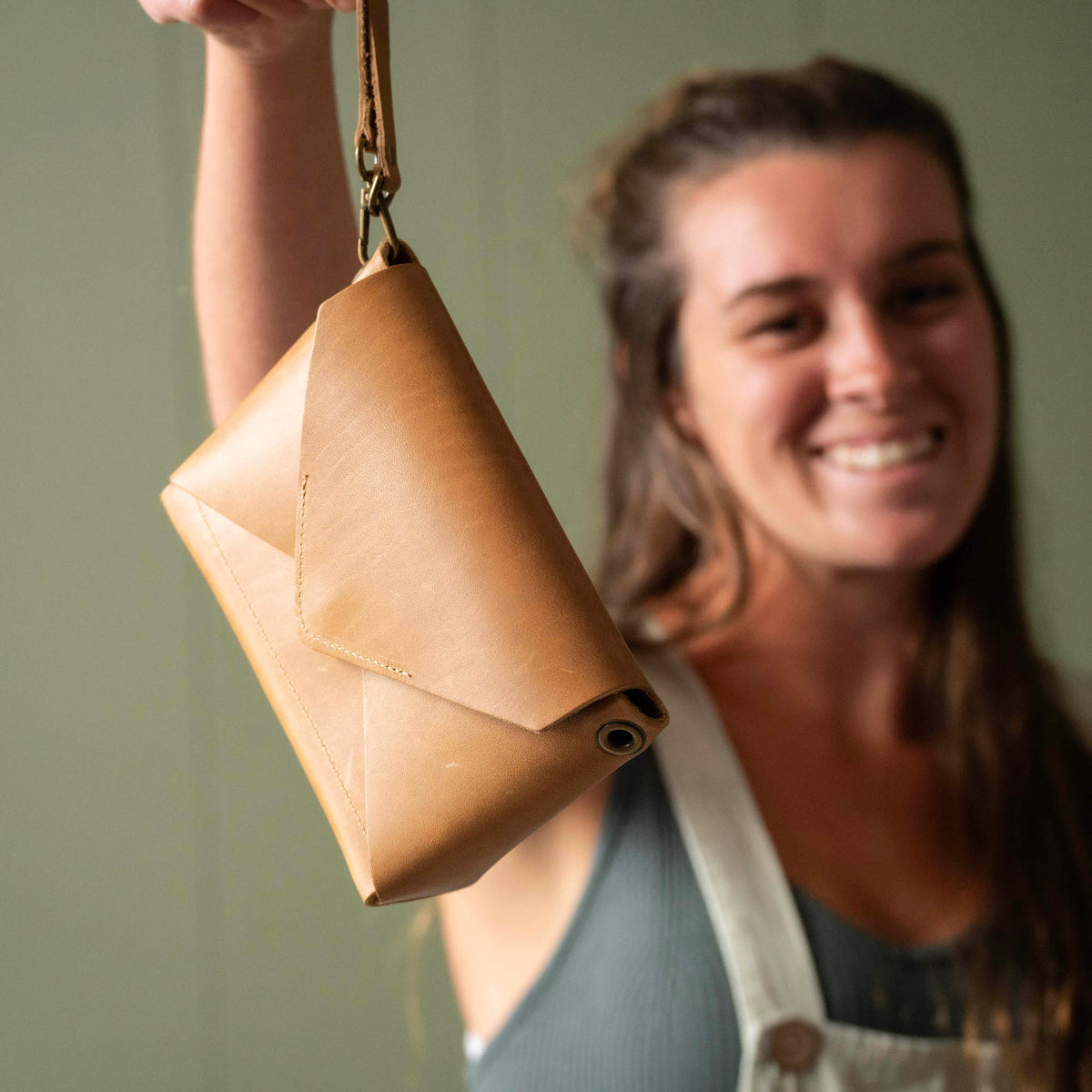 Handmade envelope purse featuring 3 in 1 leather strap. Wear as a clutch, wristlet, crossbody, or over the shoulder. Made with full grain leather. Available in black, brown, or tan.
