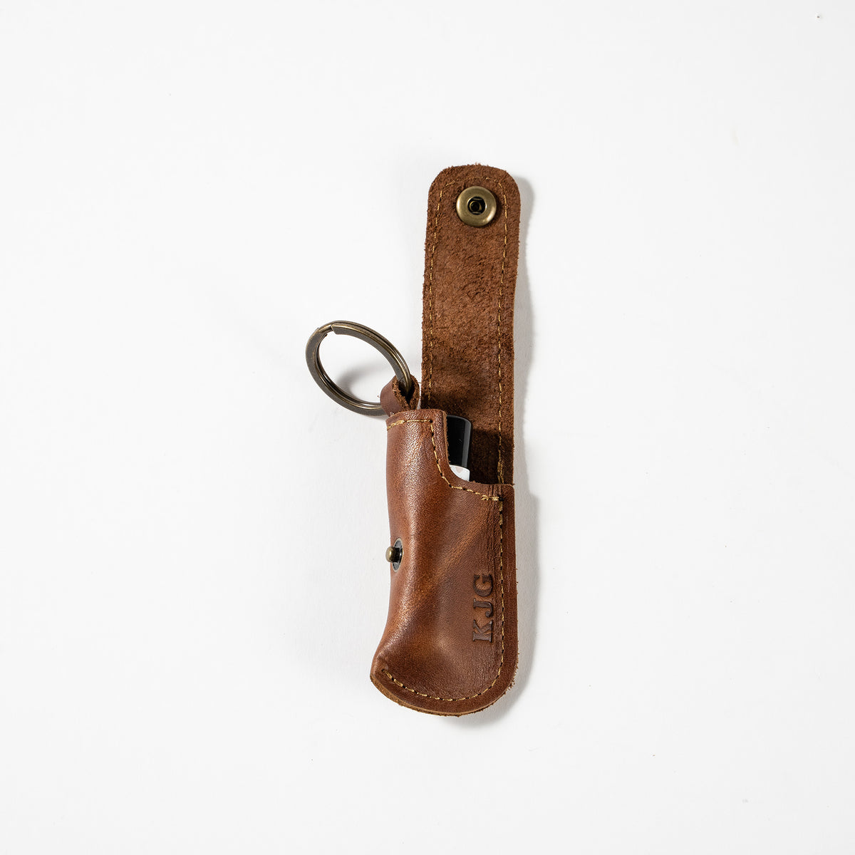 Keychain lip balm holder featuring button snap closure. Made with full-grain American leather. Customize with your initials. Makes for the perfect gift or stocking stuffer. Available in black or brown leather.
