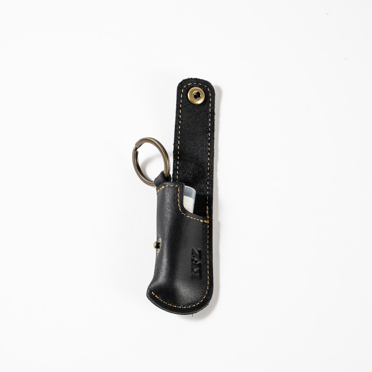 Keychain lip balm holder featuring button snap closure. Made with full-grain American leather. Customize with your initials. Makes for the perfect gift or stocking stuffer. Available in black or brown leather.