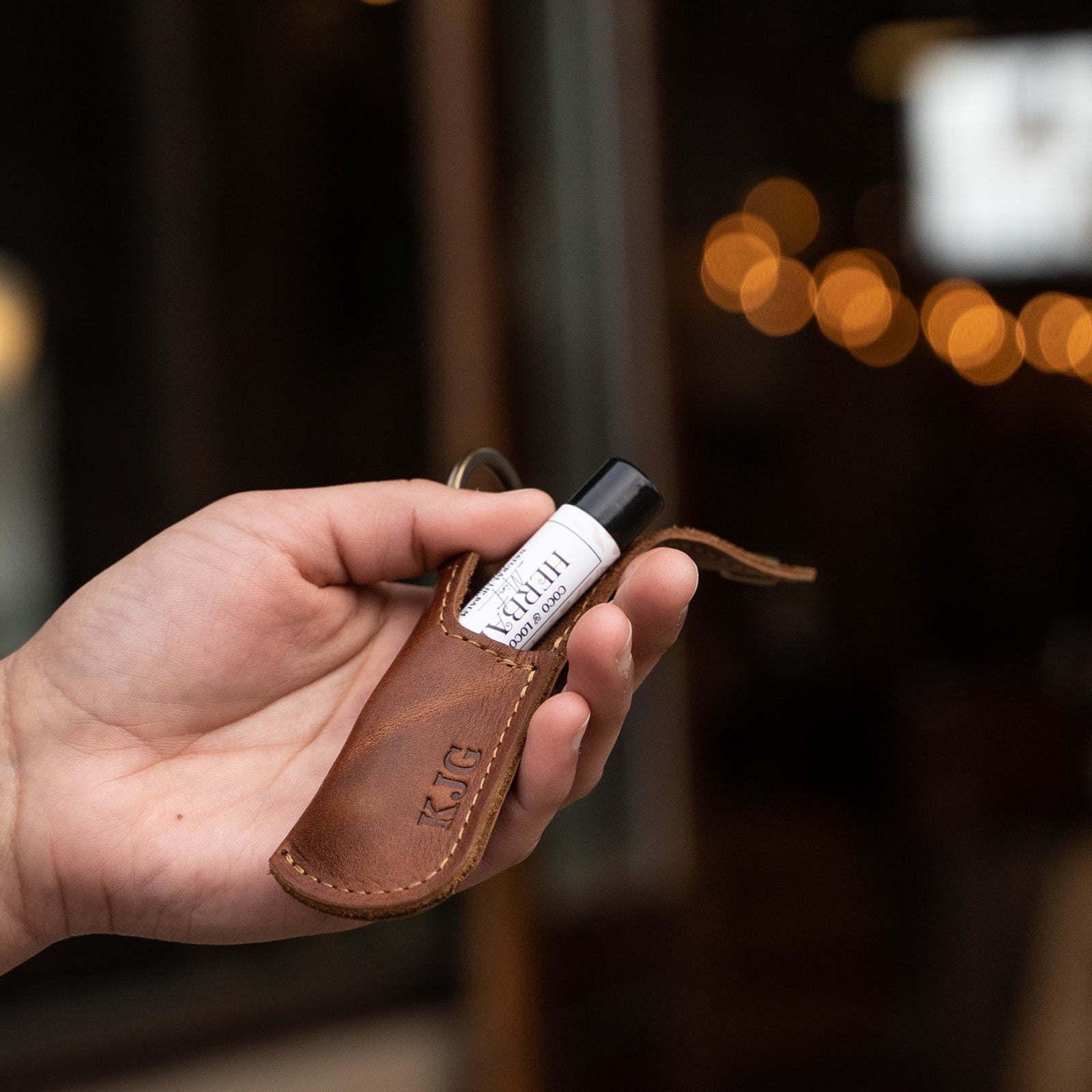 Keychain lip balm holder featuring button snap closure. Made with full-grain American leather. Customize with your initials. Makes for the perfect gift or stocking stuffer. Available in black or brown leather.
