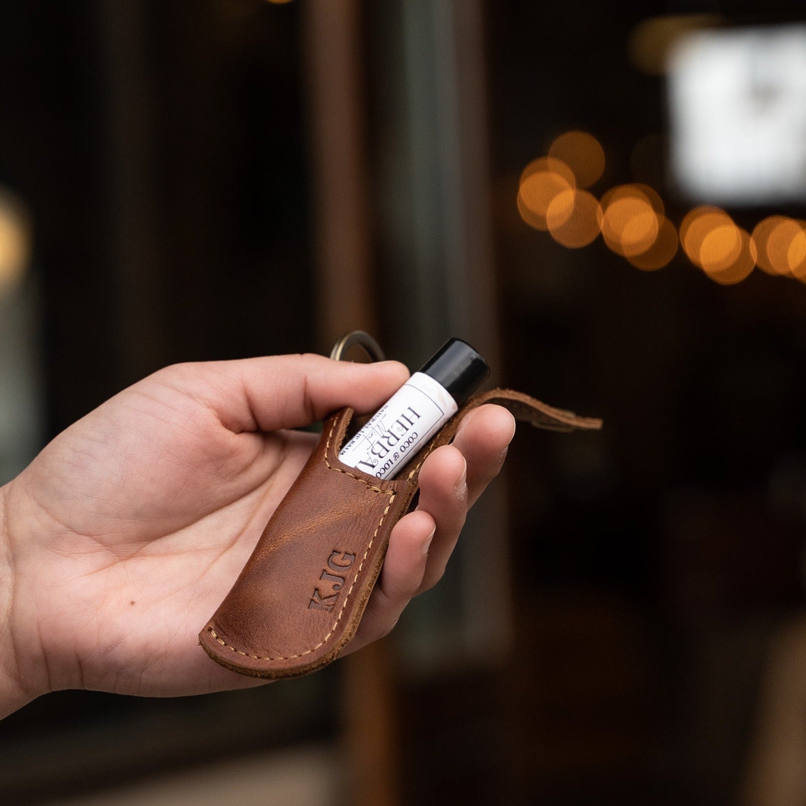 Keychain lip balm holder featuring button snap closure. Made with full-grain American leather. Customize with your initials. Makes for the perfect gift or stocking stuffer. Available in black or brown leather.