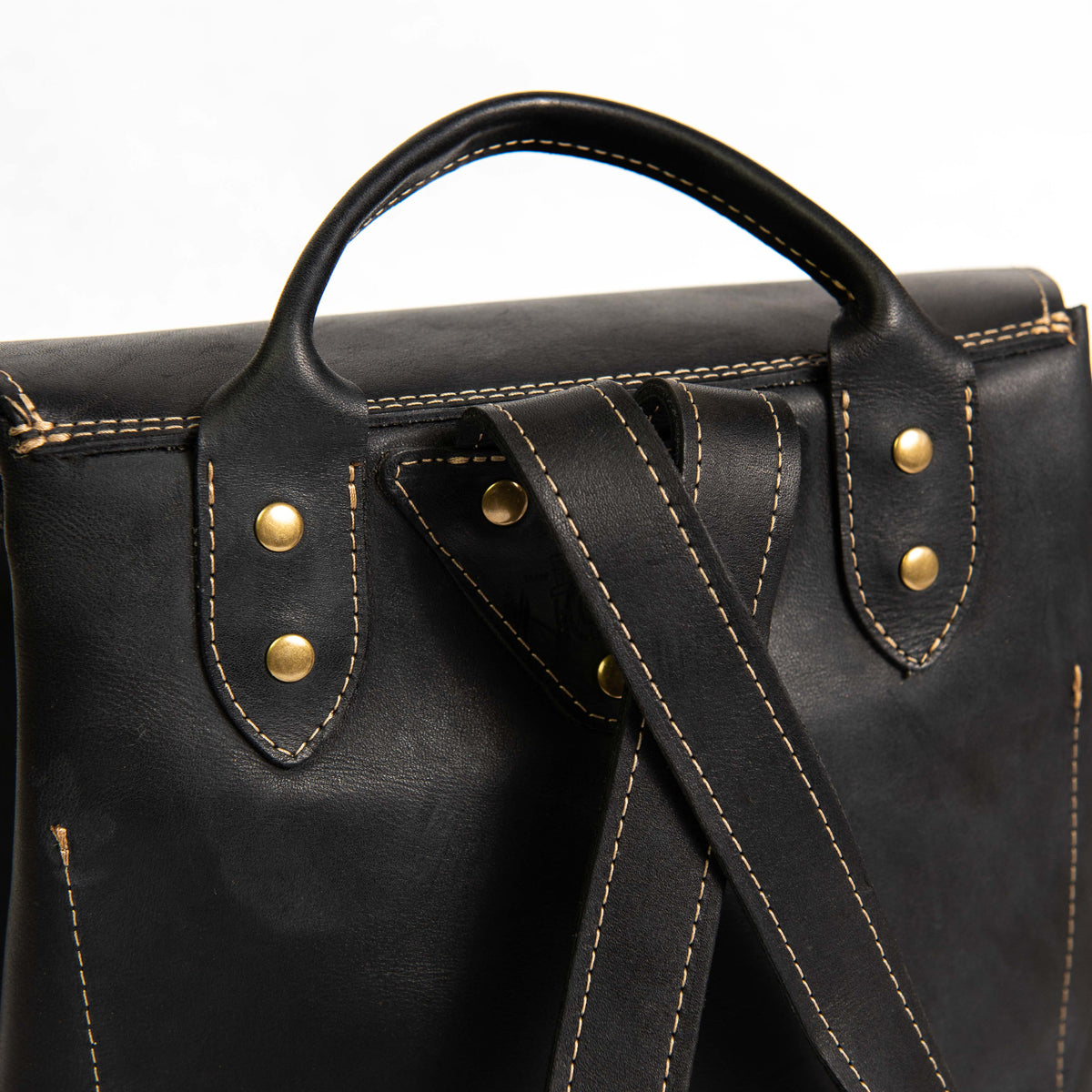 Hand made full grain leather backpack with drawstring slap closure. It features a main compartment with an interior pocket, two outer pockets, and a side pocket. Available in black or brown leather.