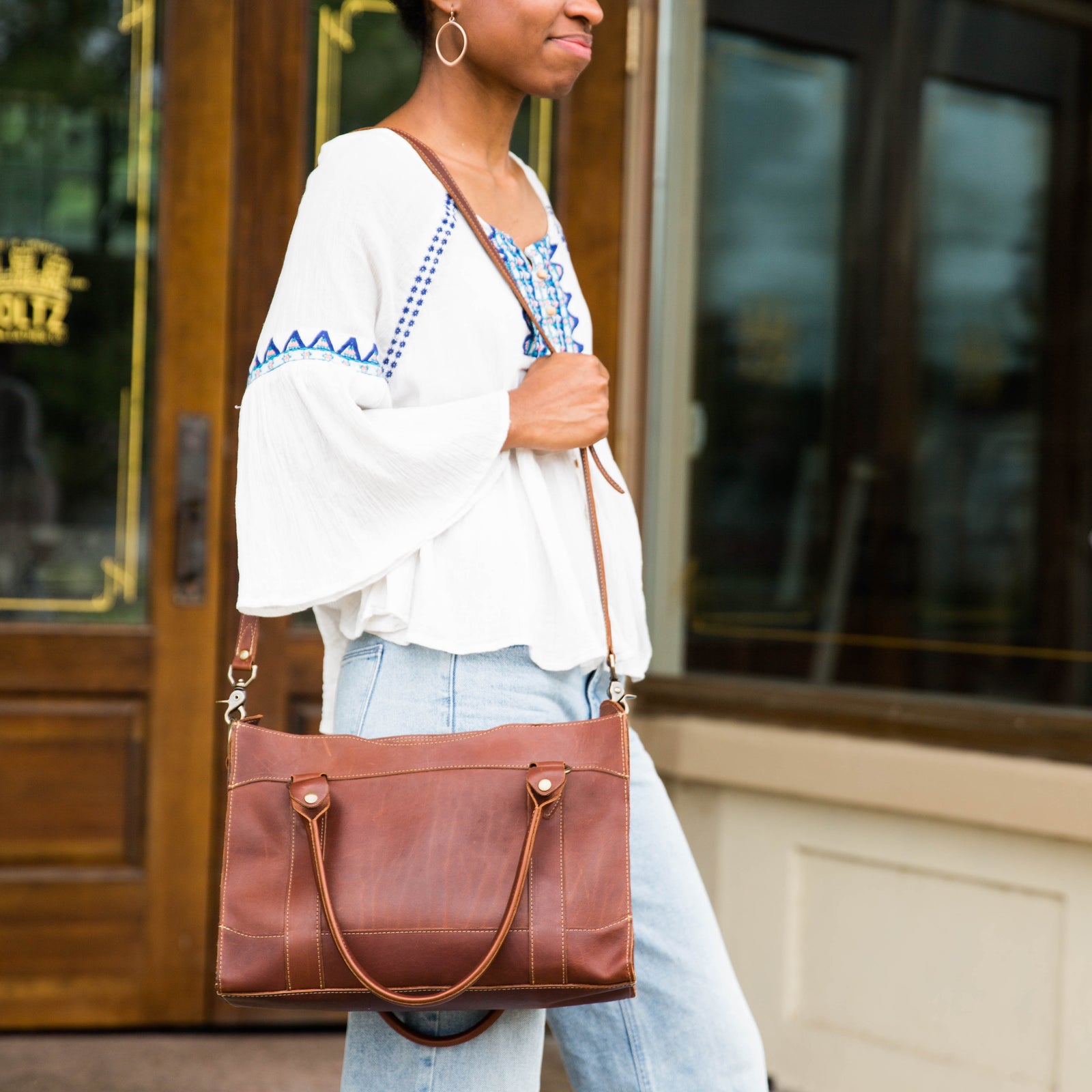 Fine leather handbag over a woman's shoulder at Shoporiaz Co in Huntsville, Alabama
